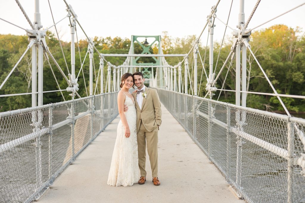 Bride and Groom smiling on bridge at The Black Bass Hotel